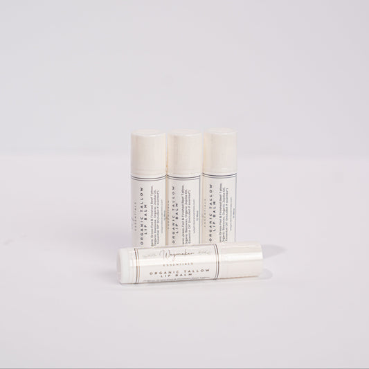 Three white cylindrical products with text on a light gray background - organic lip balm