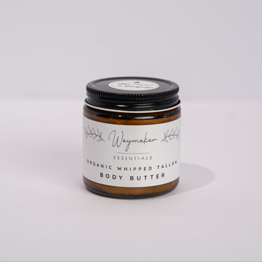 Jar of body butter with a black lid on a white background